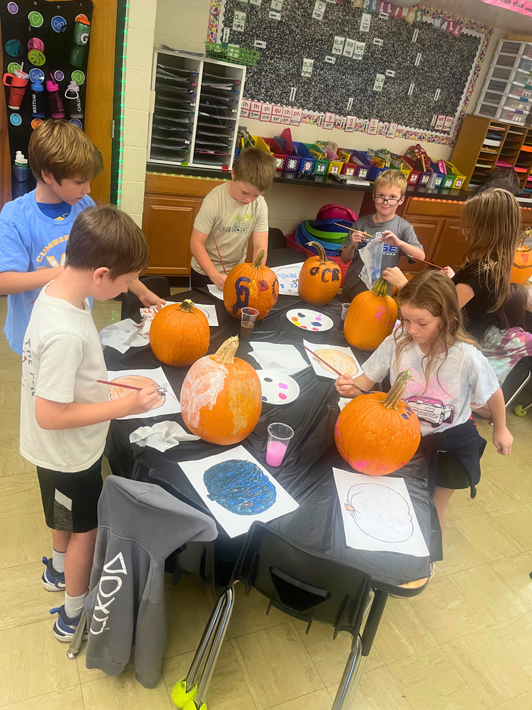 Students are painting their pumpkins. 