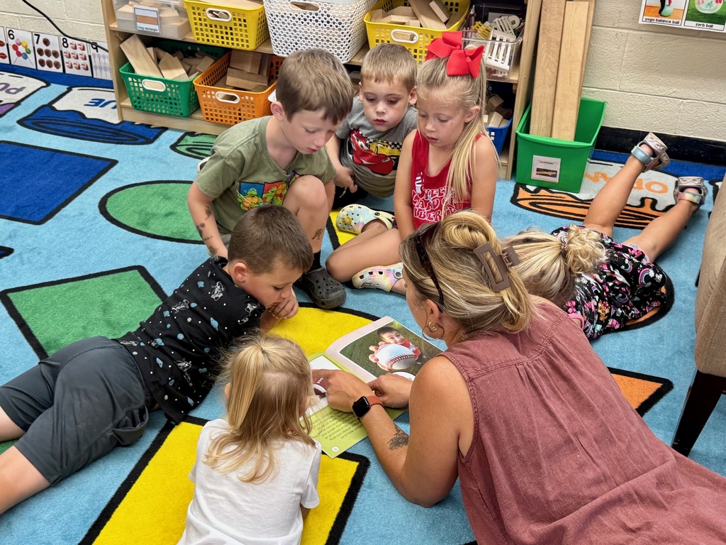 Mrs. Waller is reading a book to the students. 
