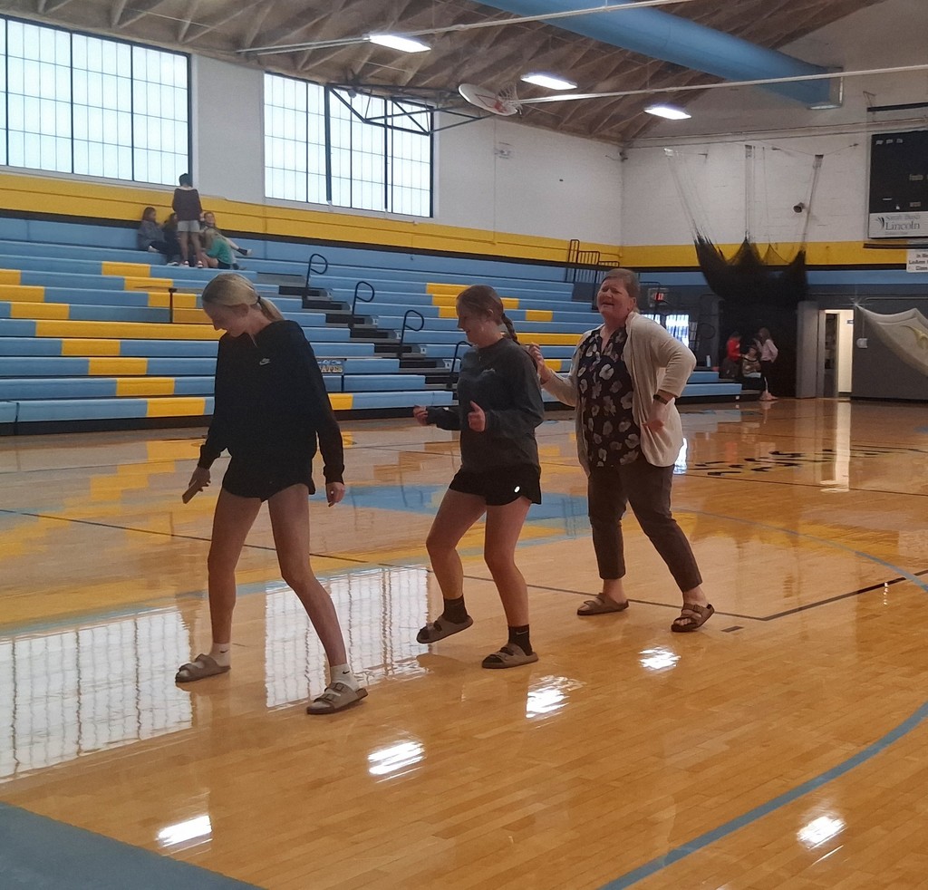 Three individuals are line dancing.