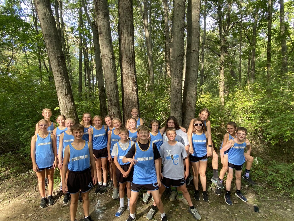 This is a picture of the cross country team standing near the woods.