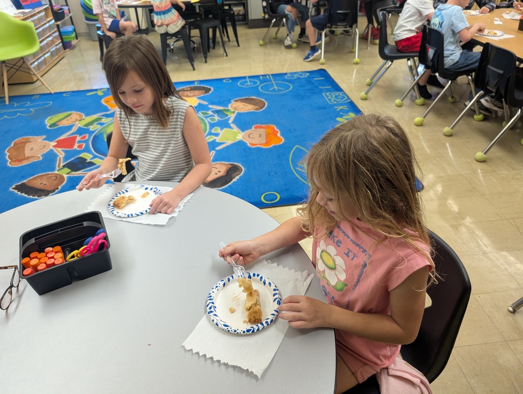 Two students are eating apple pie.