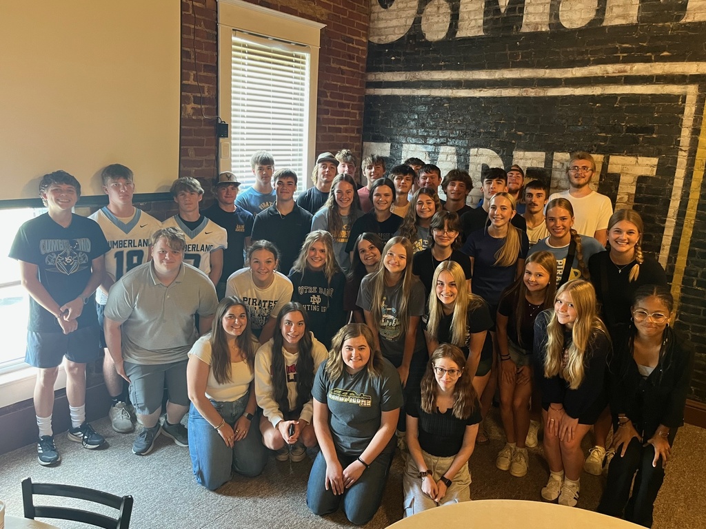 This is a group photo of all of the Foods 1 students. They are standing in front of a brick wall.