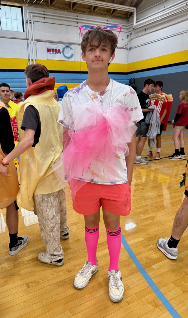 One student is dressed as cotton candy. He is wearing bright pink socks, pink touel, and pink sunglasses.