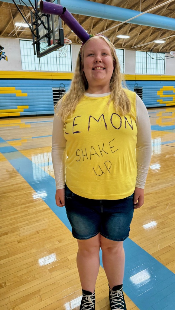 One student is dressed as a lemon shake-up. She has a purple straw coming from her head. She has a yellow t-shirt that says lemon shake up.