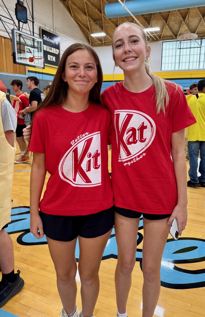 Two students are standing side by side. One is one half of a Kit kat bar, and the other is the other half.