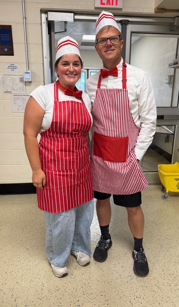 The two individuals are dressed as concession stand workers. They are wearing red and white striped aprons with a whiteand red hat.and red