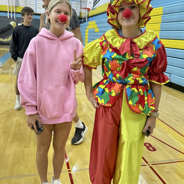 Tuesday student side at one is a clown. The other is wearing pink and giving the peace sign.