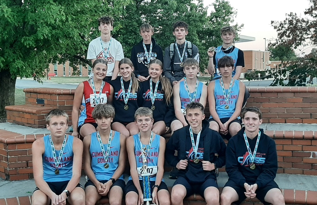 The girls and boys medalists are sitting on the concrete walls.