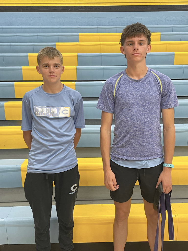 The two all-conference boys runners are standing side by side. They are not wearing their medals.