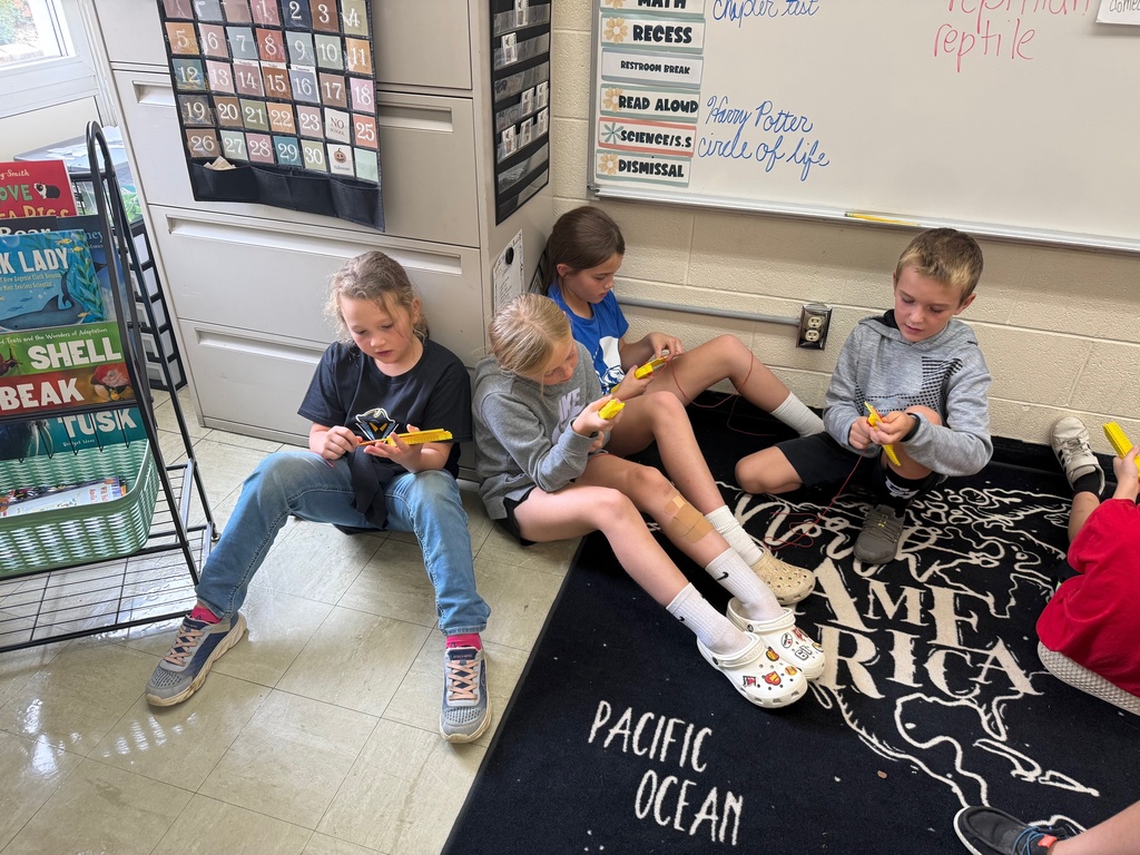 Four students are sitting together using multiplication math fidgets and math "keys" to practice their math facts.