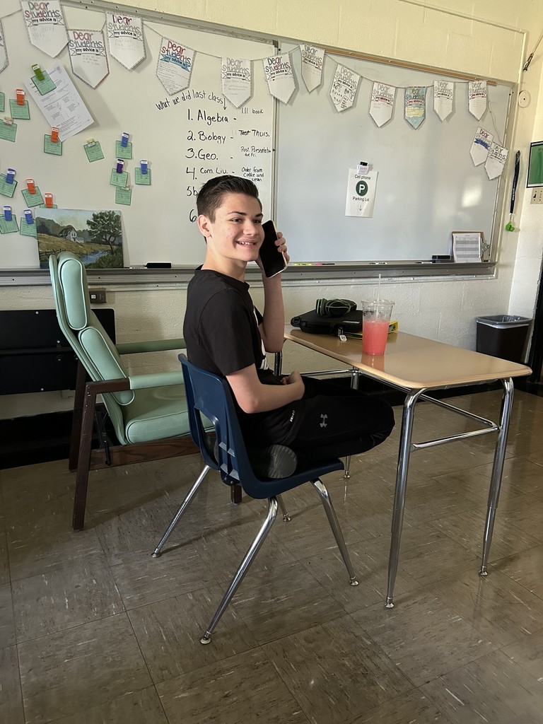 A student is calling in his order to Coffee and Creams. He is sitting at his desk.