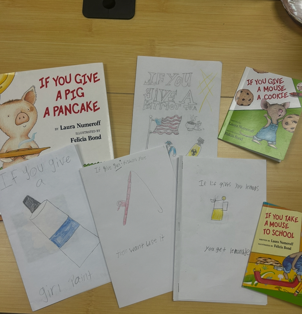 A collection of published and student-made children's books arranged on a wooden table, inspired by Laura Numeroff's "If You Give..." series. Official titles include If You Give a Pig a Pancake, If You Give a Mouse a Cookie, and If You Take a Mouse to School. Hand-drawn covers show creative twists like If You Give a Girl Paint featuring a paint tube, If You Give a Patriot Tea with American flags and a teacup, and If Life Gives You Lemons, You Get Lemonade with a pitcher and glass. One student-made book shows a fishing pole with the caption "If you give [a] fishing pole, they won’t use it."