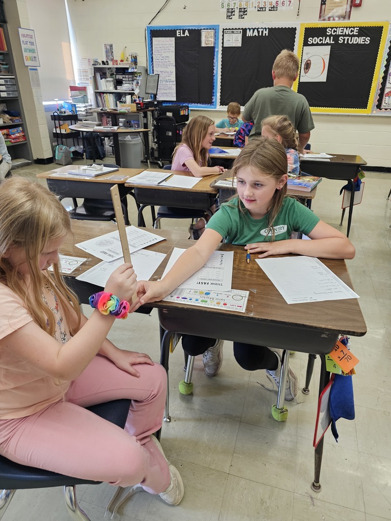 One student is holding a ruler. The second student has her hand below the ruler ready to catch it.