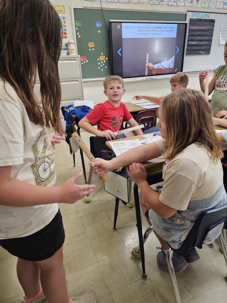 One student is holding a ruler. The second student has her hand below the ruler ready to catch it. She caught the ruler.