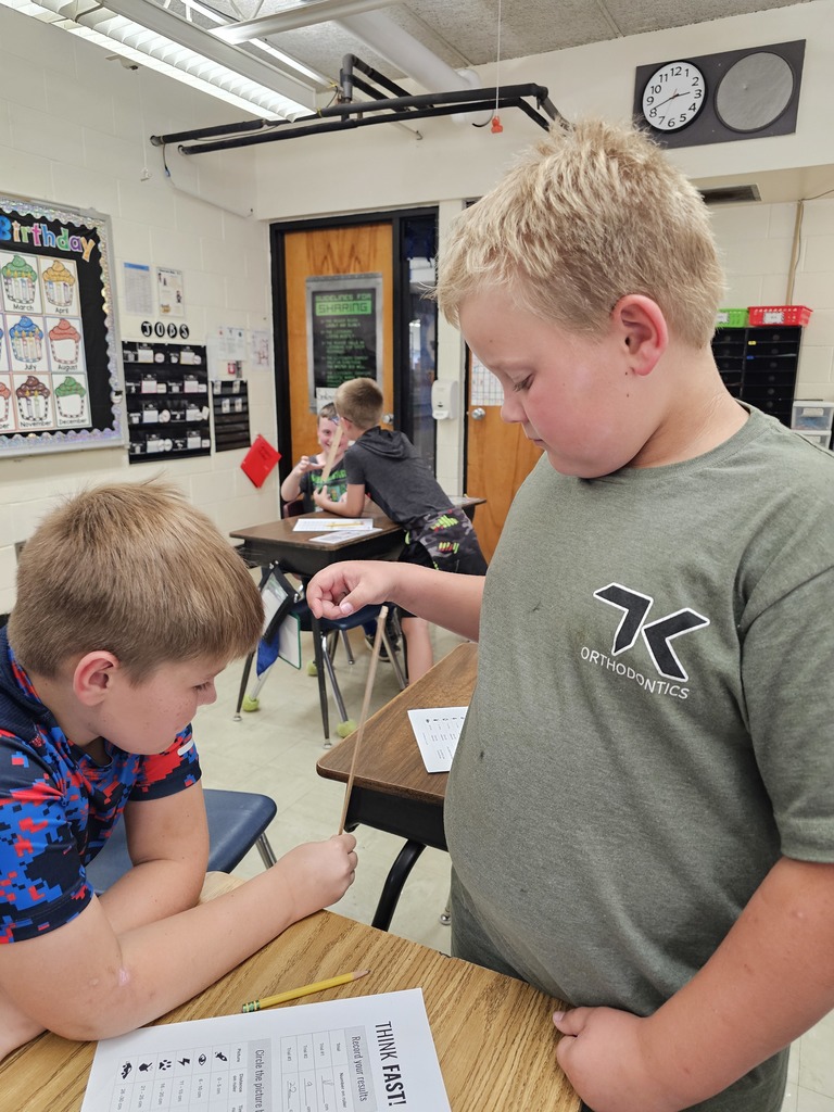 One student is holding a ruler. The second student has his hand below the ruler ready to catch it. He caught the ruler.