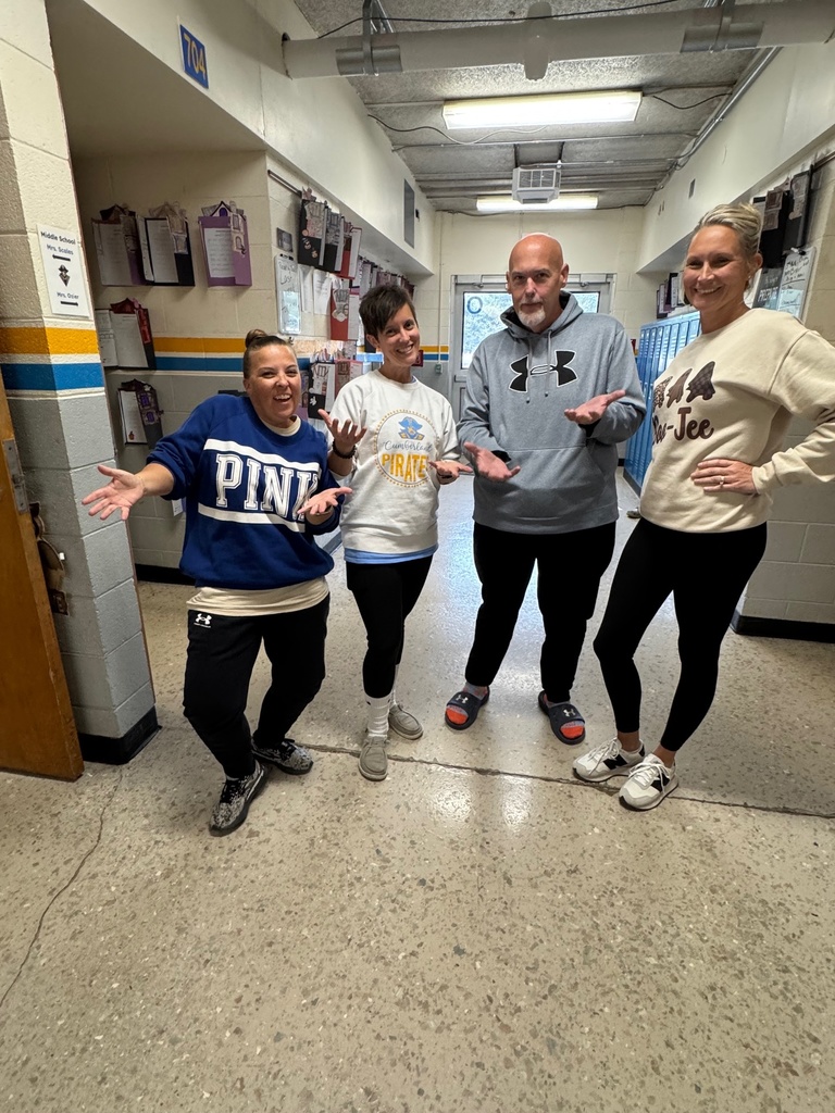 The four teachers are wearing gym pants and sweatshirts. They have socks and shoes. They are making hand gestures as the students do.