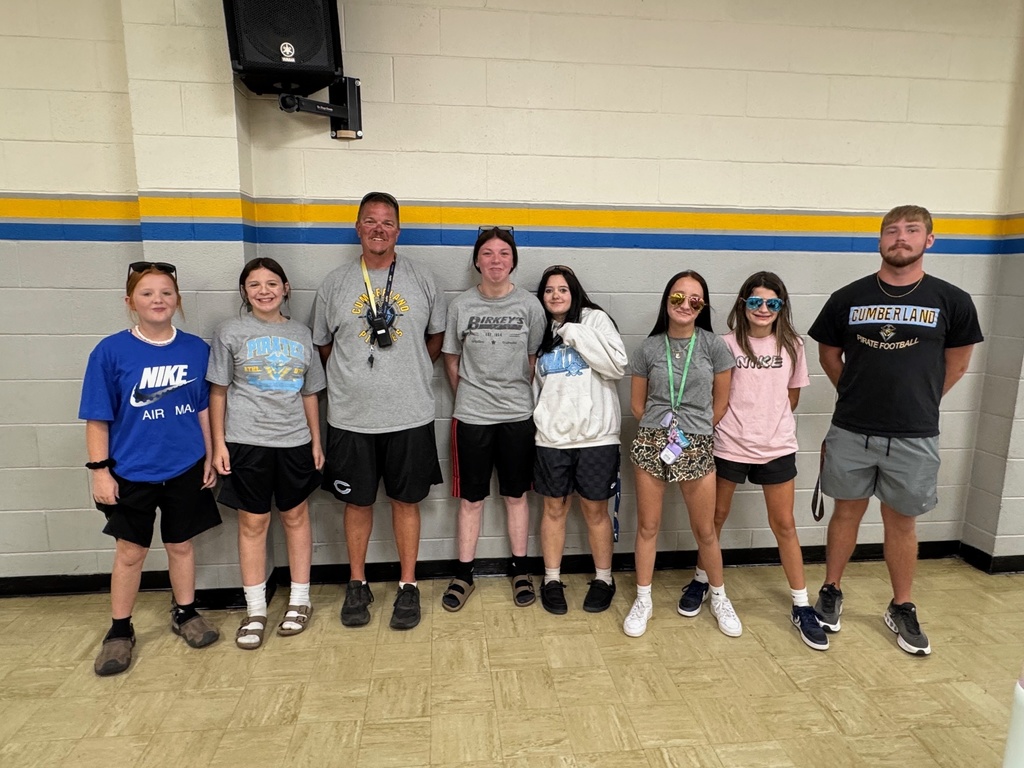 Six students are wearing t-shirts, shorts, socks and shoes. Some have lanyards and sunglasses. The two teacher are wearing the same.