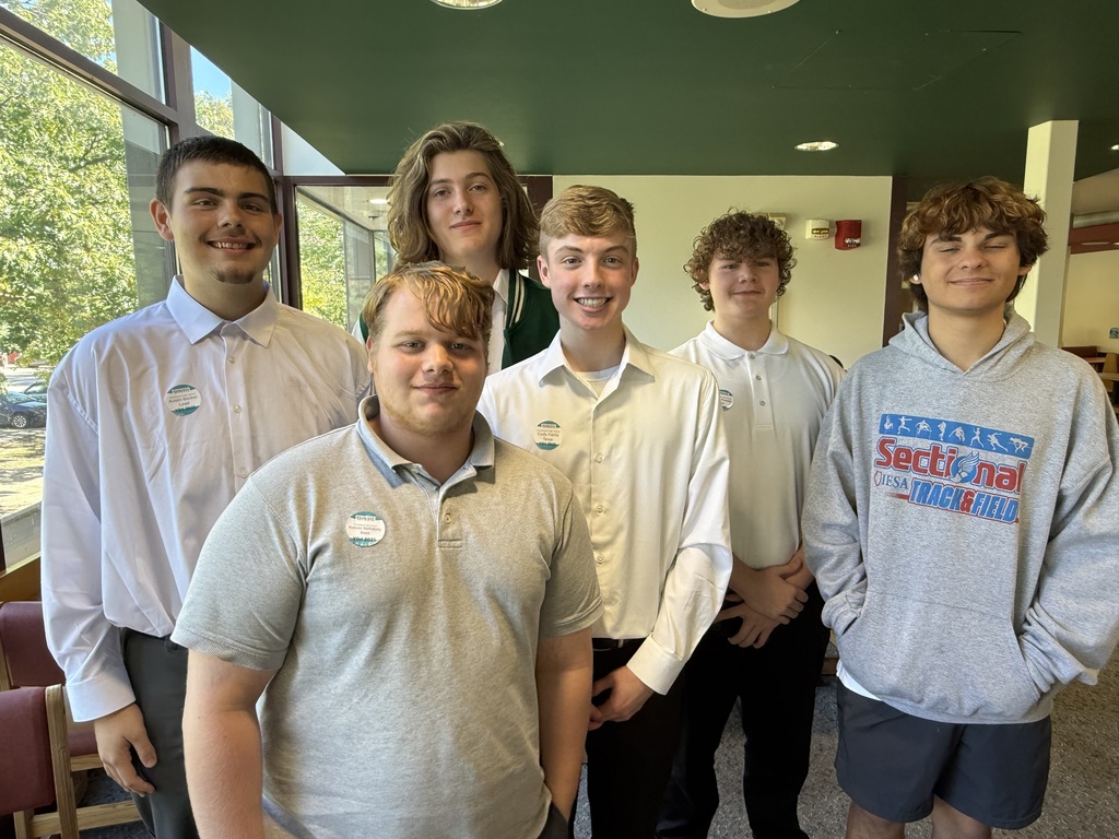 Five male students are standing in three rows. They are smiling for the picture.