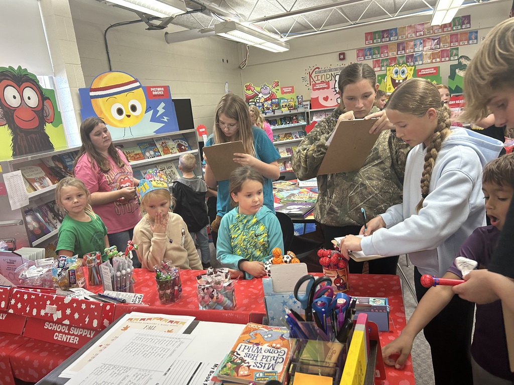 Older students are writing down lists on clipboards. Younger students are making their choices.