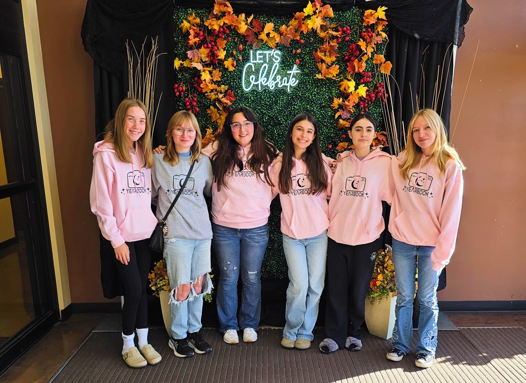 Six  students are standing side by side in front of a fall themed background that says Let's celebrate.