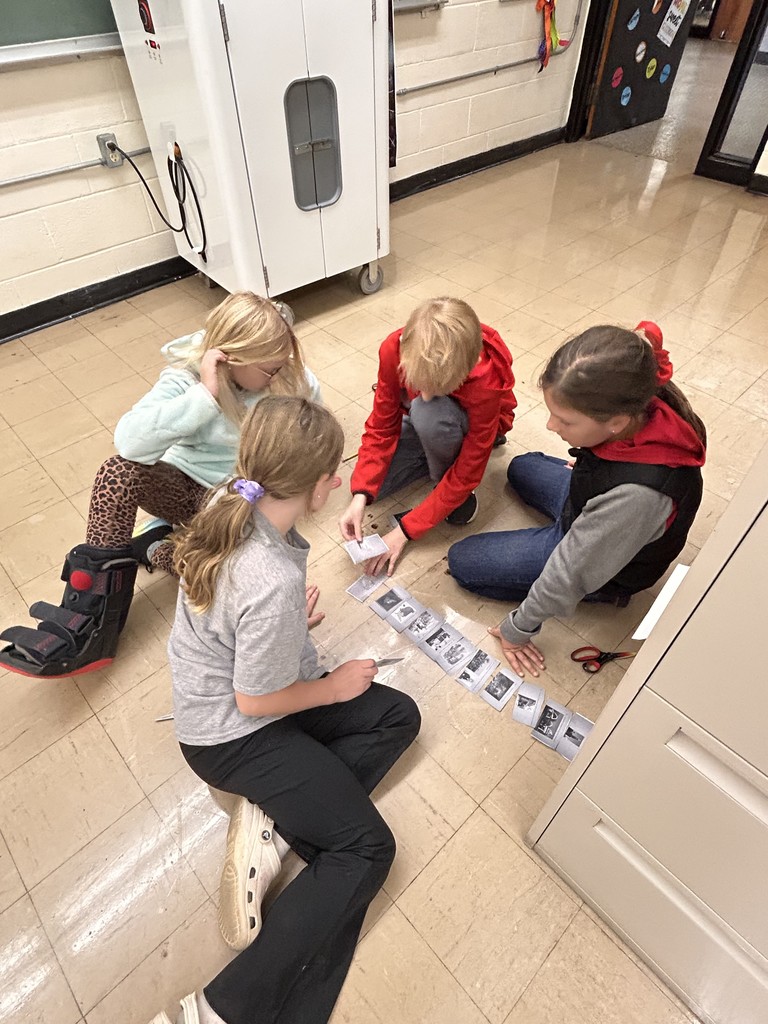Students are sitting on the floor. They are sorting Illinois history timeline.