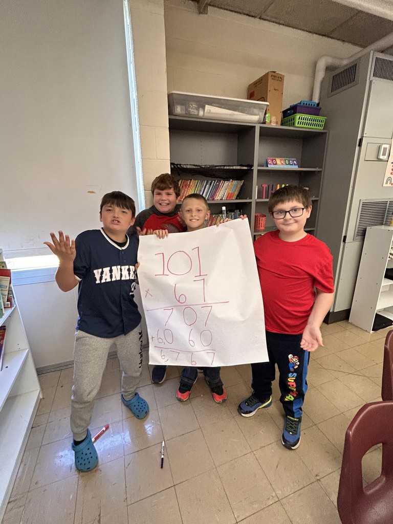 A group is holding up a paper with a math problem that had the answer of 6767.