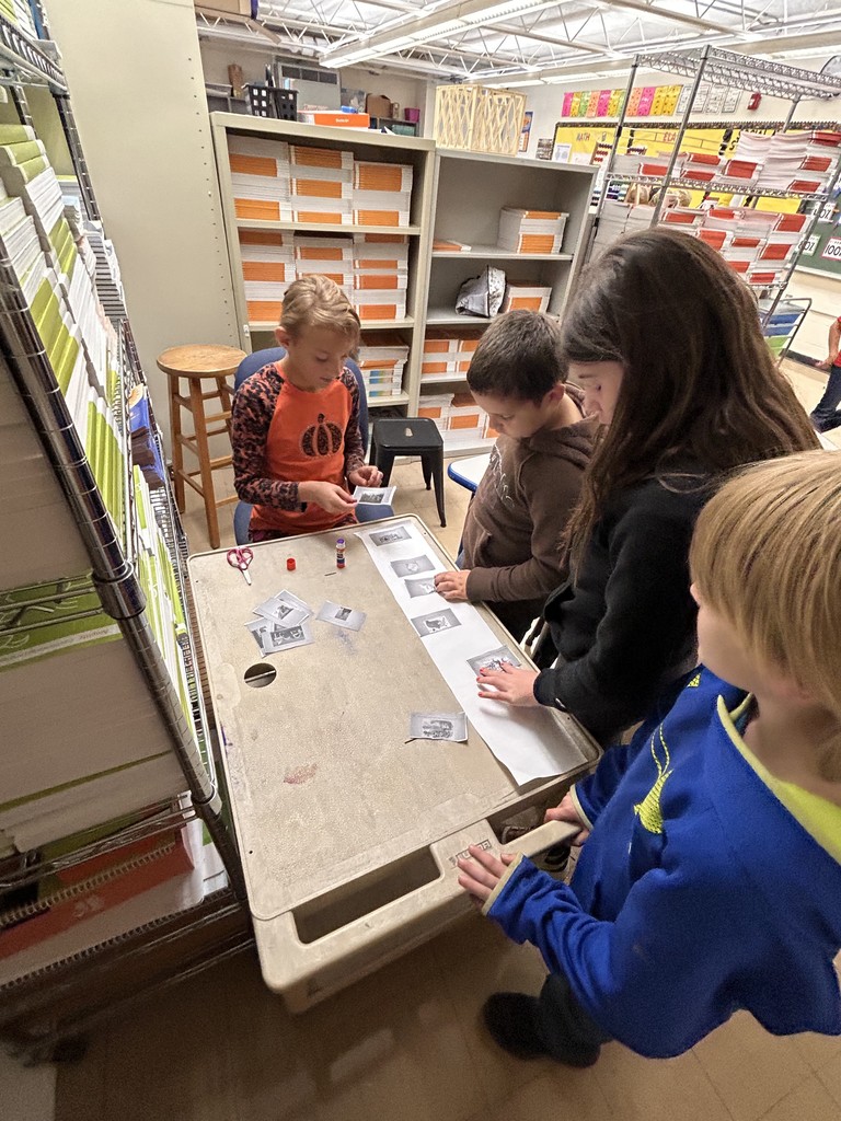 Students are standing at a cart. They are sorting Illinois history timeline.