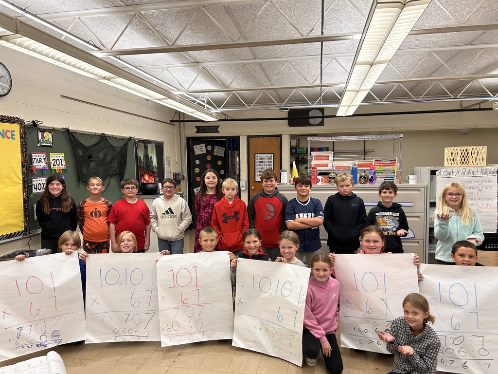 Groups are holding up a paper with a math problem that had the answer of 6767.