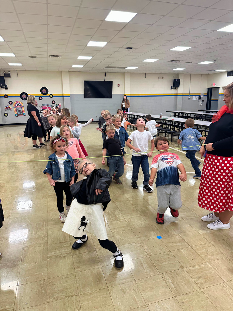 Students are dressed in 50s attire. They are doing the limbo.