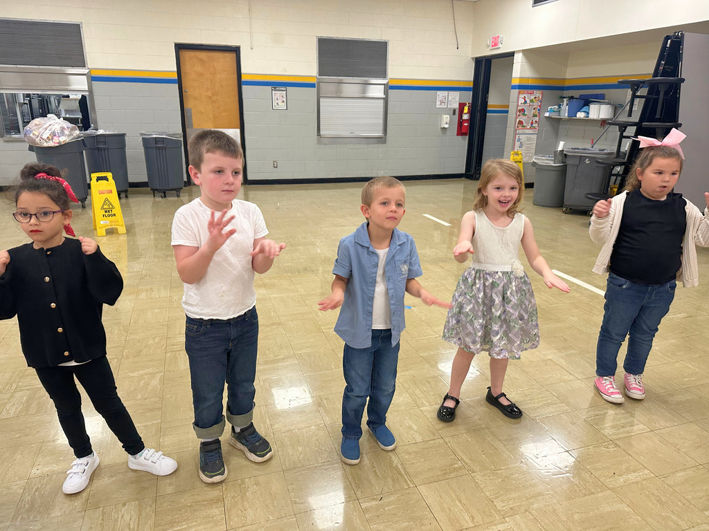Students are dressed in 50s attire. They are doing 50s dance moves.