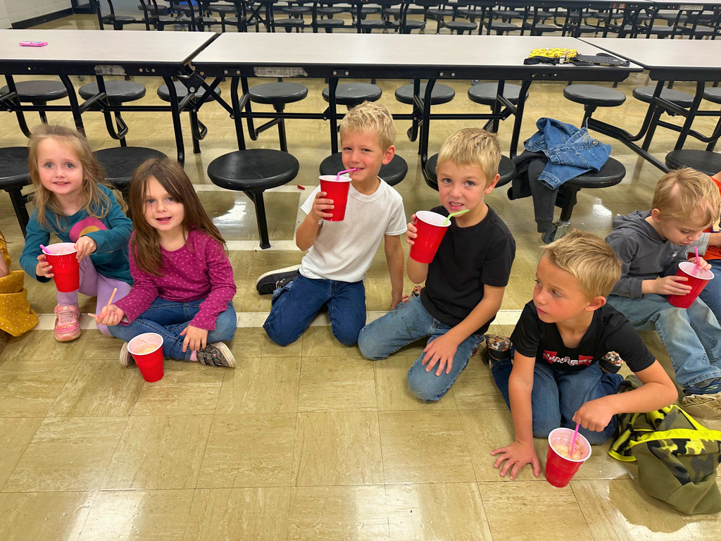 Students are dressed in 50s attire. They are drinking milkshakes.