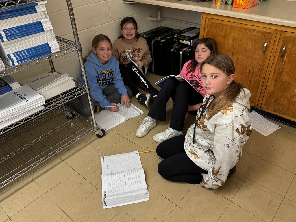 Students are working in a group writing ideas in their books for a fable.