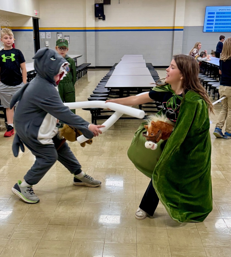 Two students are having a joust. They are riding stick ponies and have white pool noodles as their weapon.