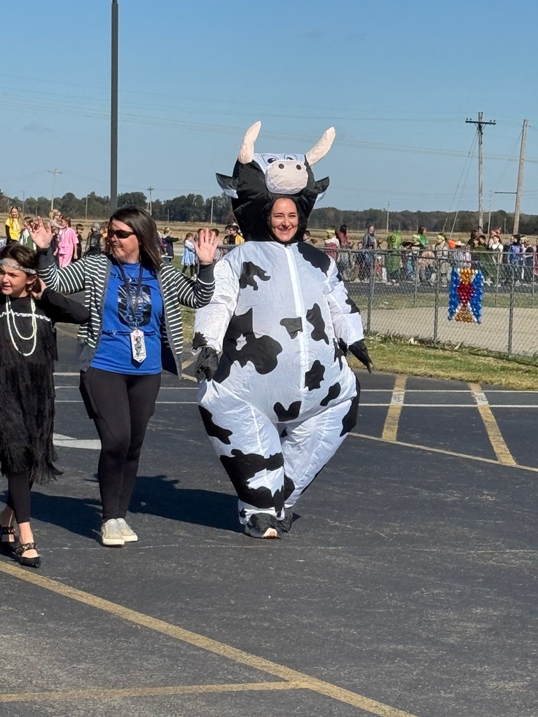 Students and staff are dressed in Halloween costumes and walking in the parade.