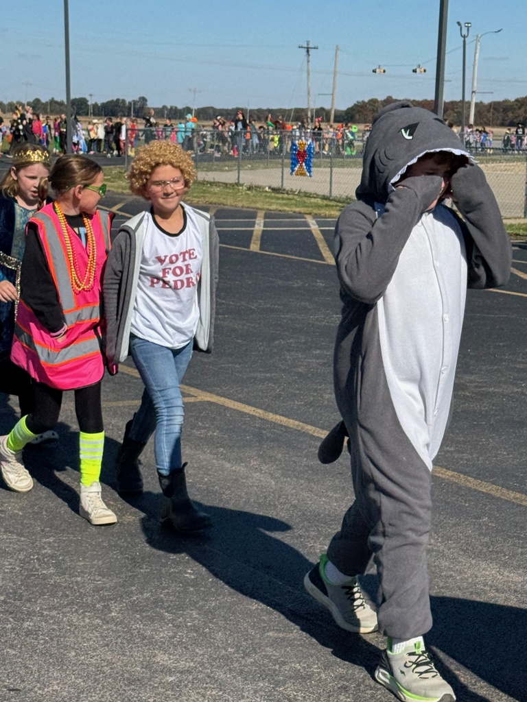 Students and staff are dressed in Halloween costumes and walking in the parade.