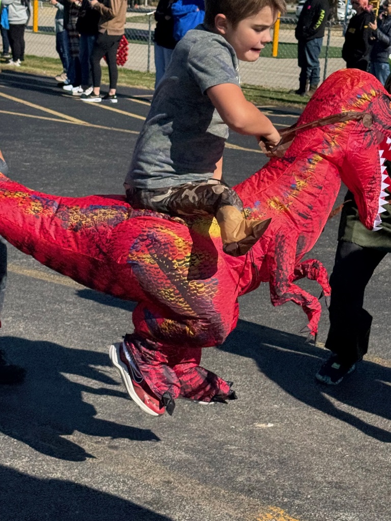Students and staff are dressed in Halloween costumes and walking in the parade.