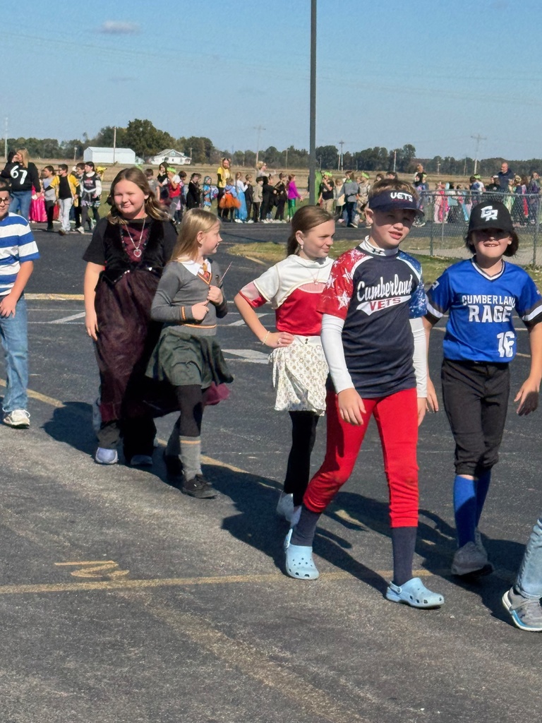 Students and staff are dressed in Halloween costumes and walking in the parade.