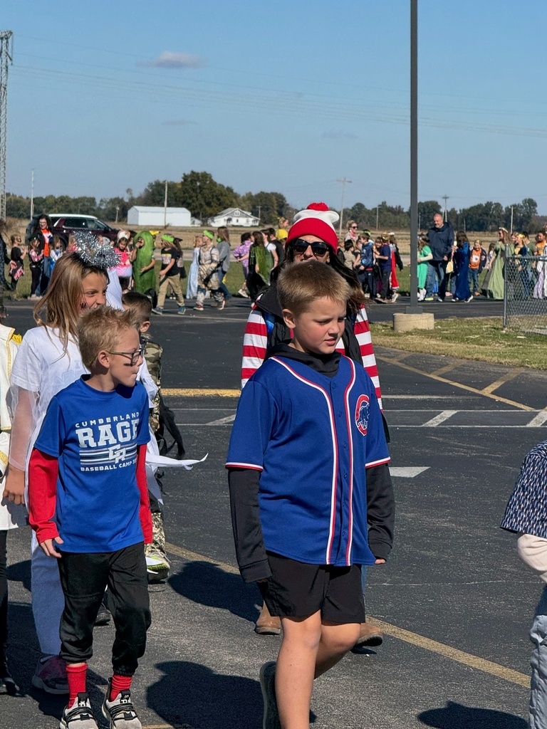 Students and staff are dressed in Halloween costumes and walking in the parade.