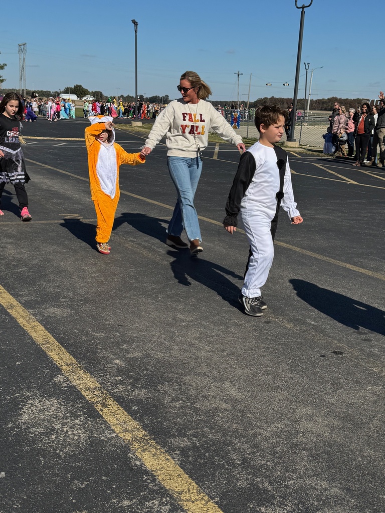 Students and staff are dressed in Halloween costumes and walking in the parade.