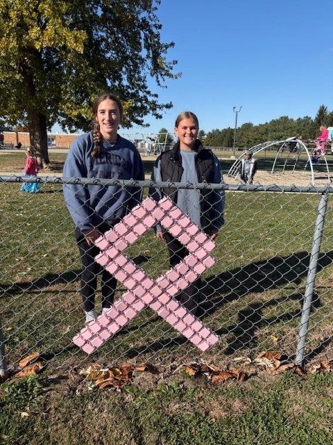 The students are standing by their design. It is a pink ribbon.