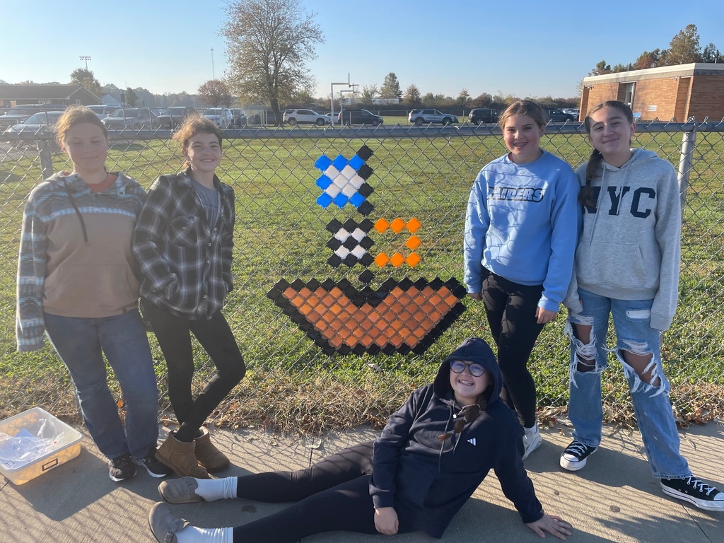 The students are standing by their design. It is a pirate ship.