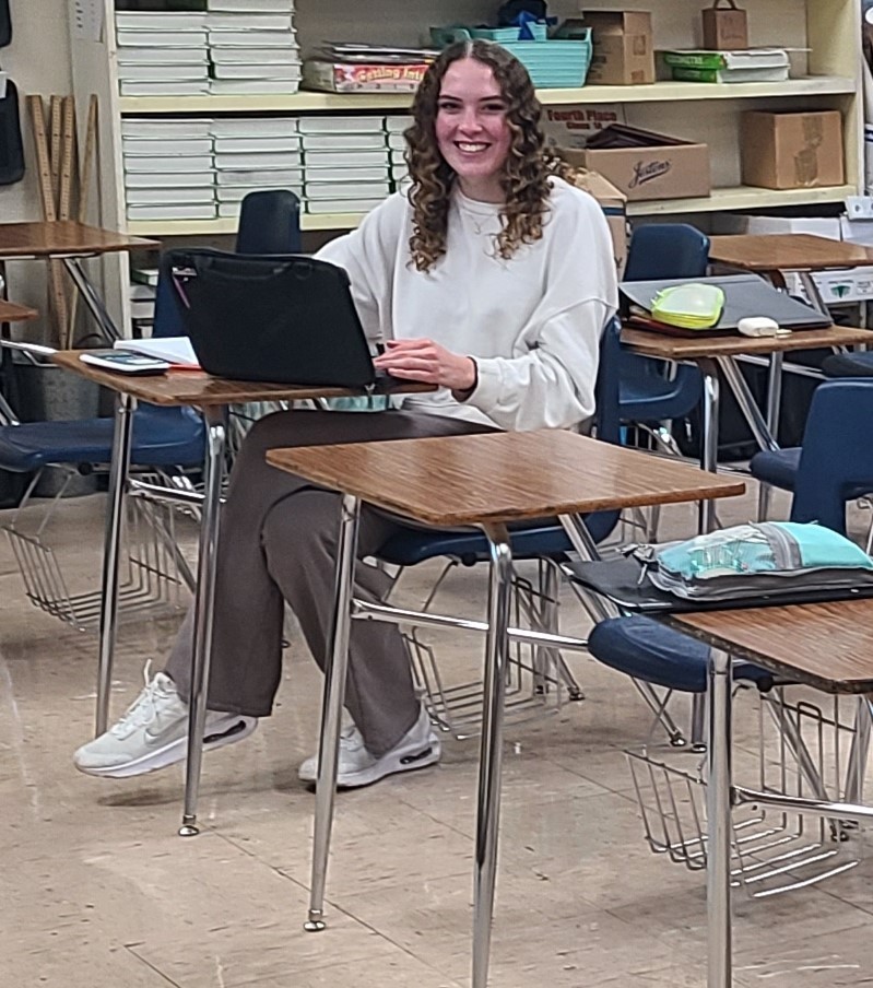 A student is sitting at a desk. The student is evaluating data.