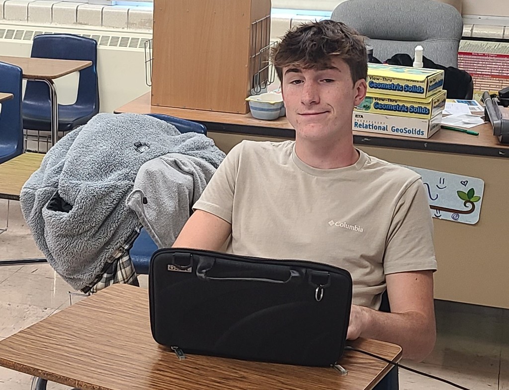 A student is sitting at a desk. The student is evaluating data.