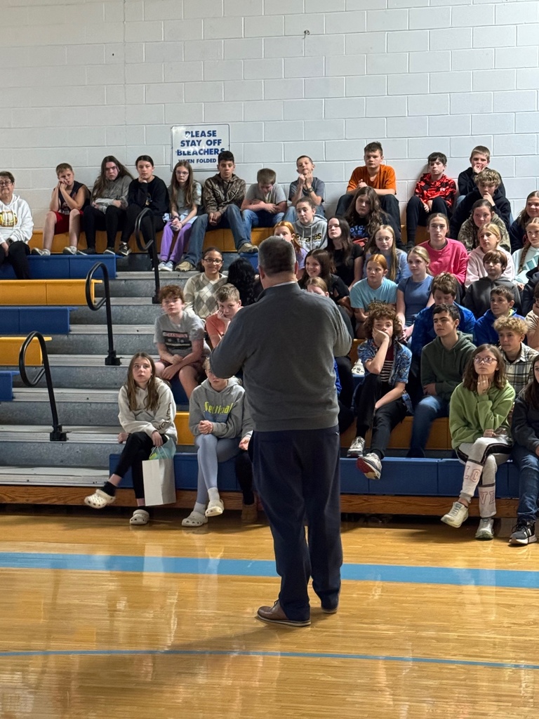 Mr. Lighty is speaking to the group in the gym. 
