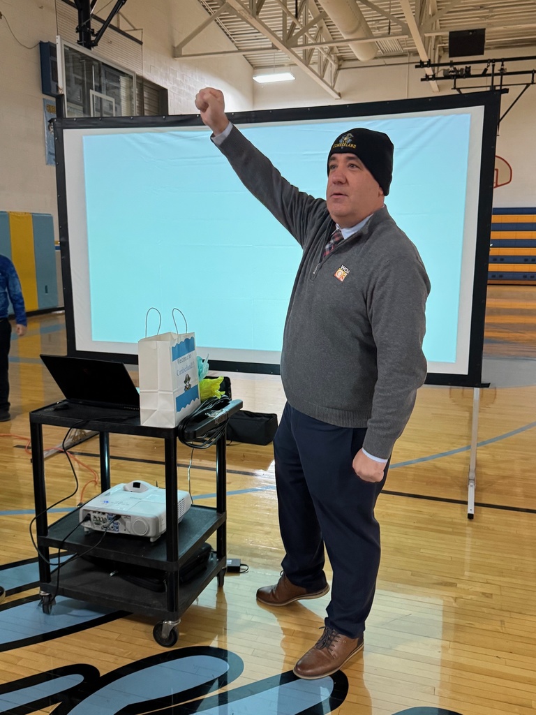 Kevin is wearing the beanie and holding his fist up high. 