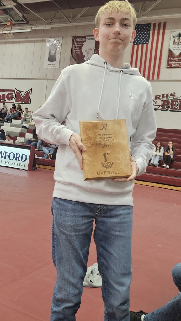 A student is holding the team's 1st place plaque. 