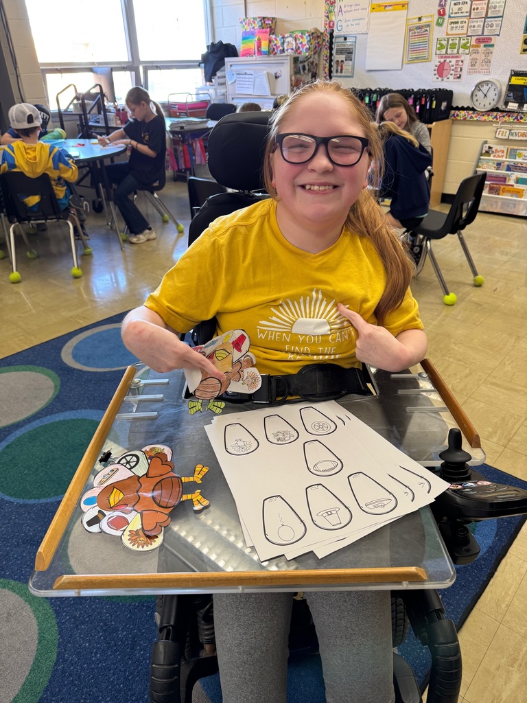 Miss Nevaeh is holding one of the sample turkeys for the class. 