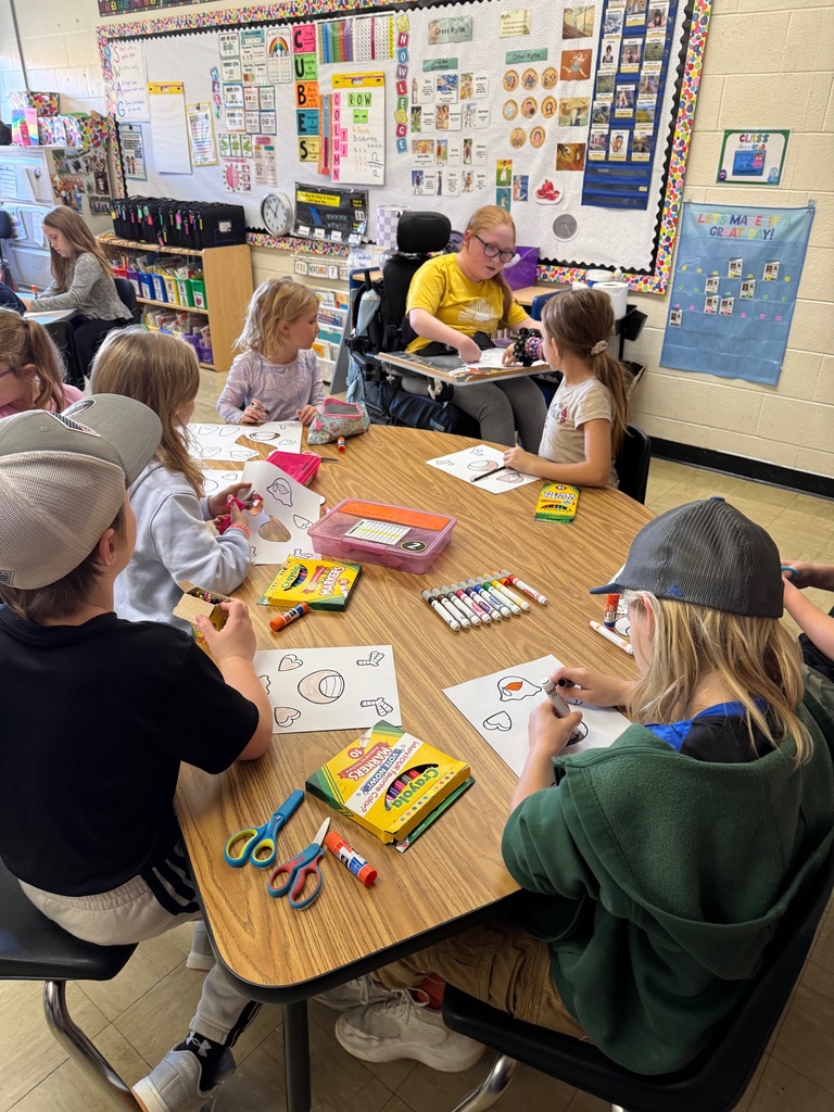 Miss Nevaeh is passing out papers to the class. 