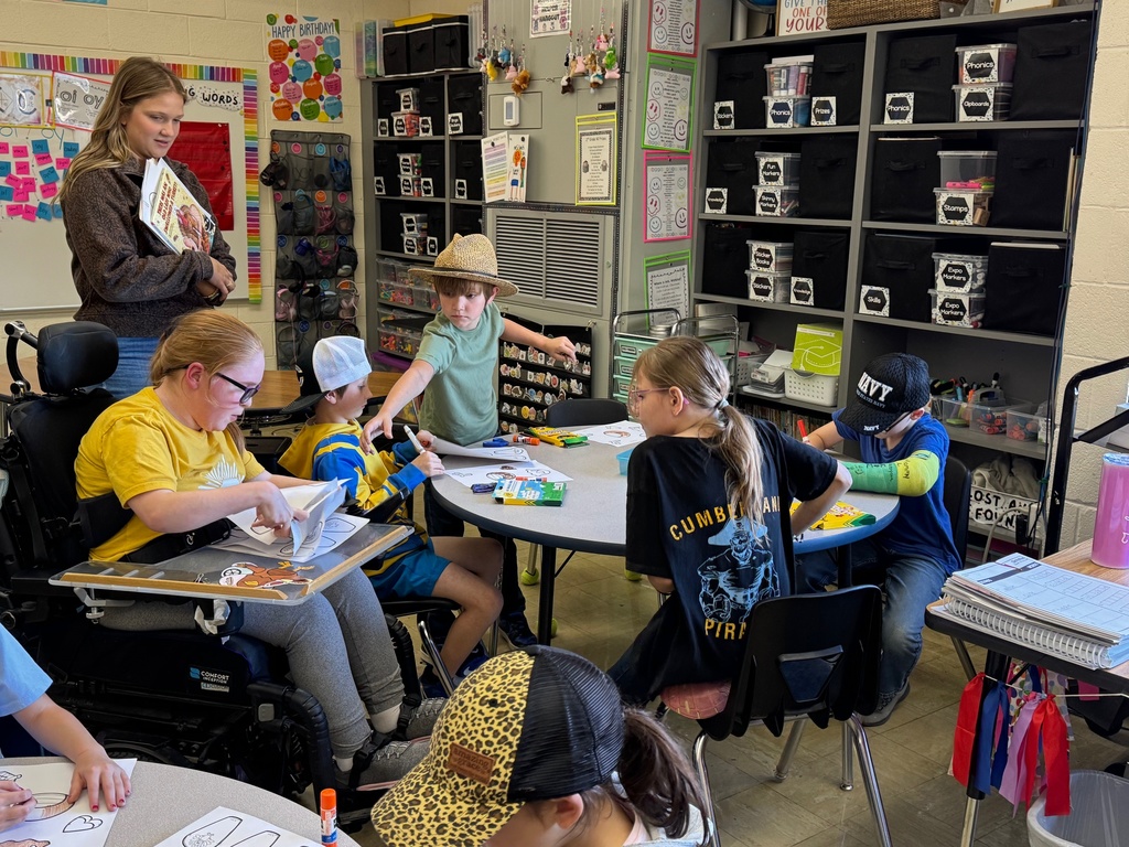 Miss Nevaeh is passing out papers to the class. 