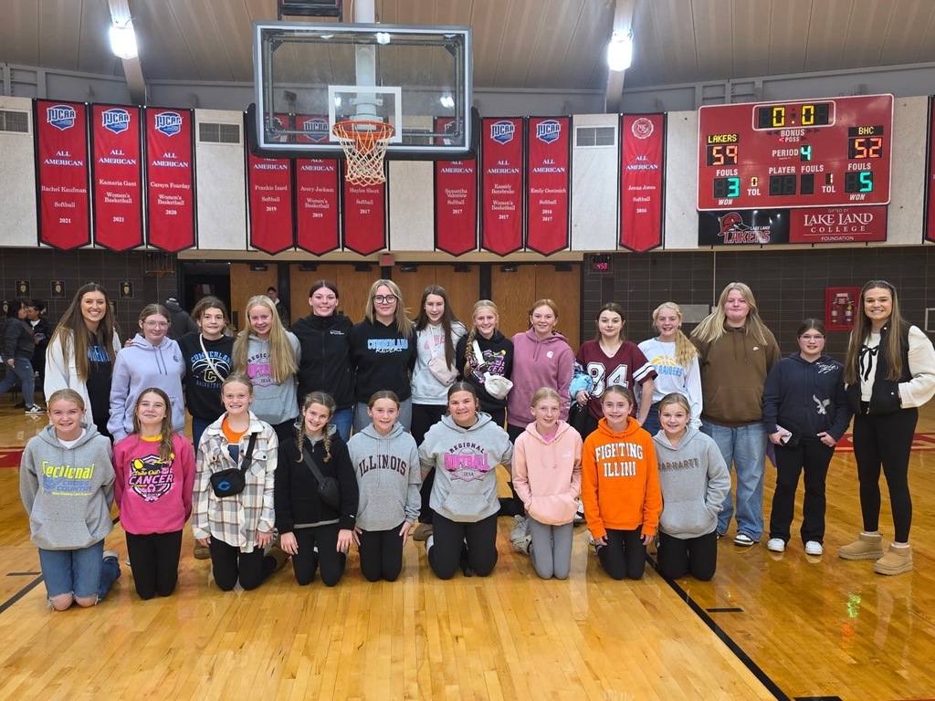 The team is posed together in two lines at the Lake Land gym. 